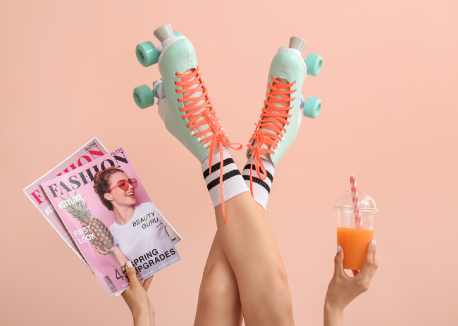 A teenager wearing rollerskates is holding a mocktail in one hand.